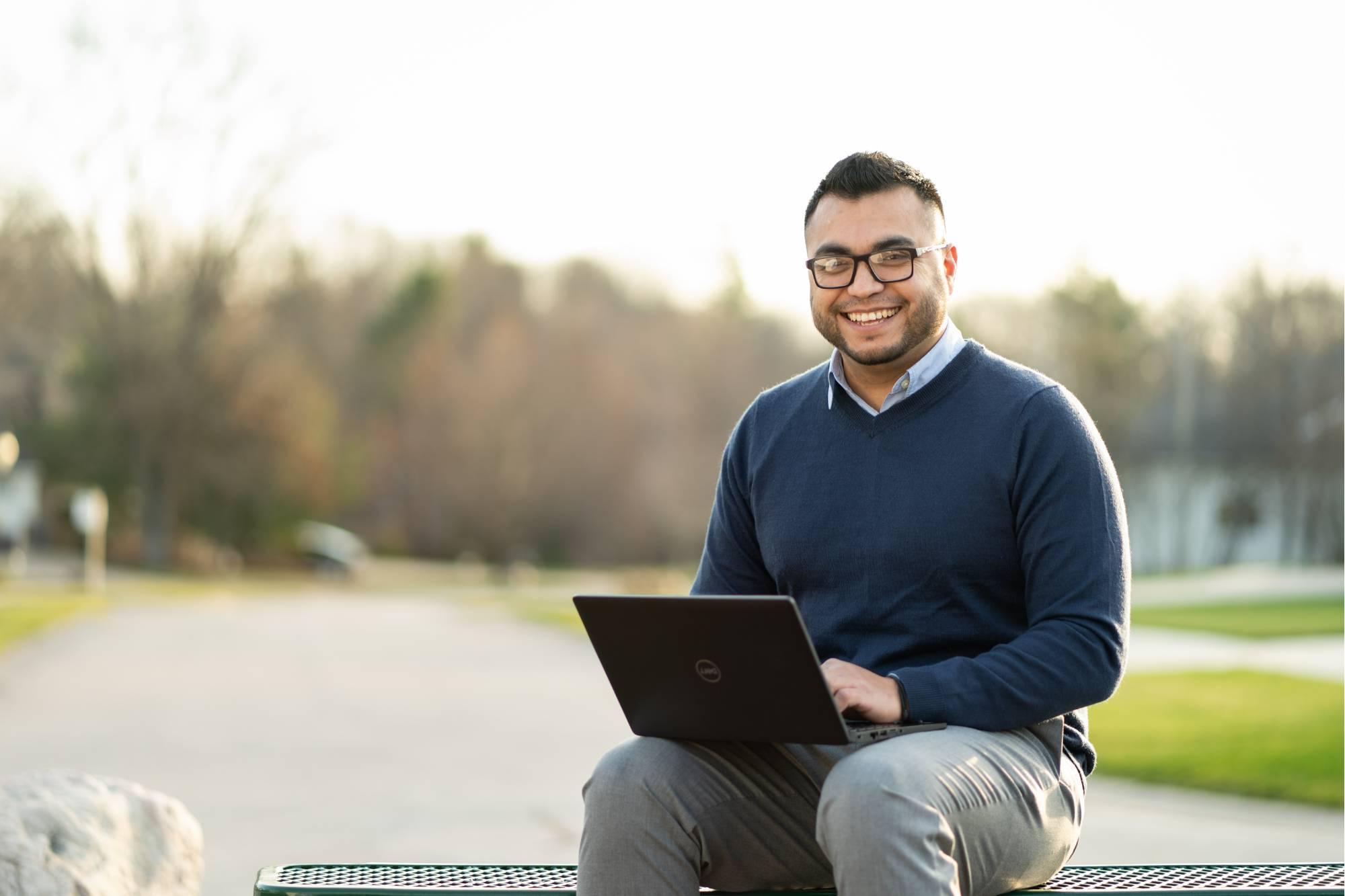 Man sitting at park with laptop